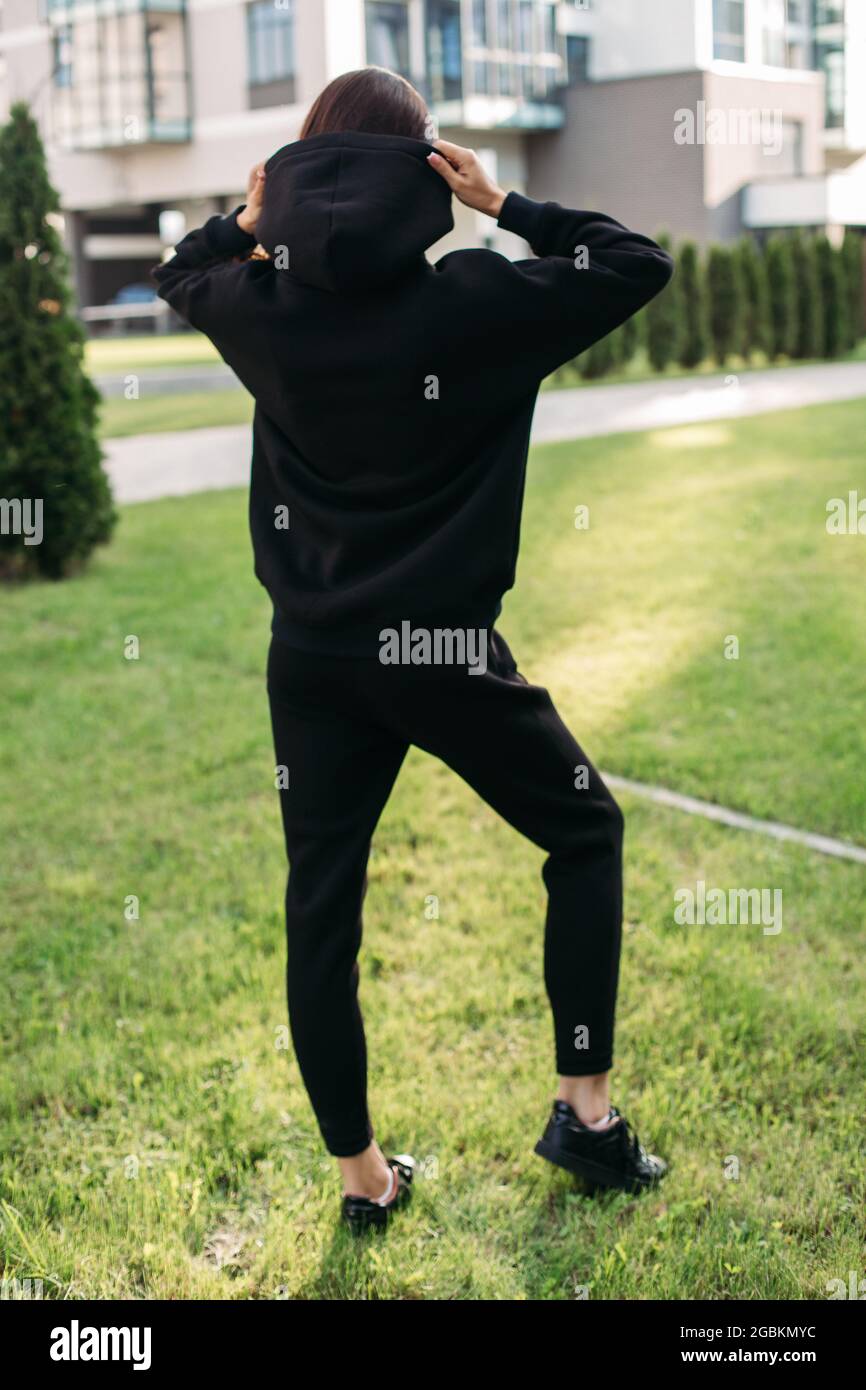 Giovane donna in abbigliamento sportivo in piedi su un prato verde Foto Stock