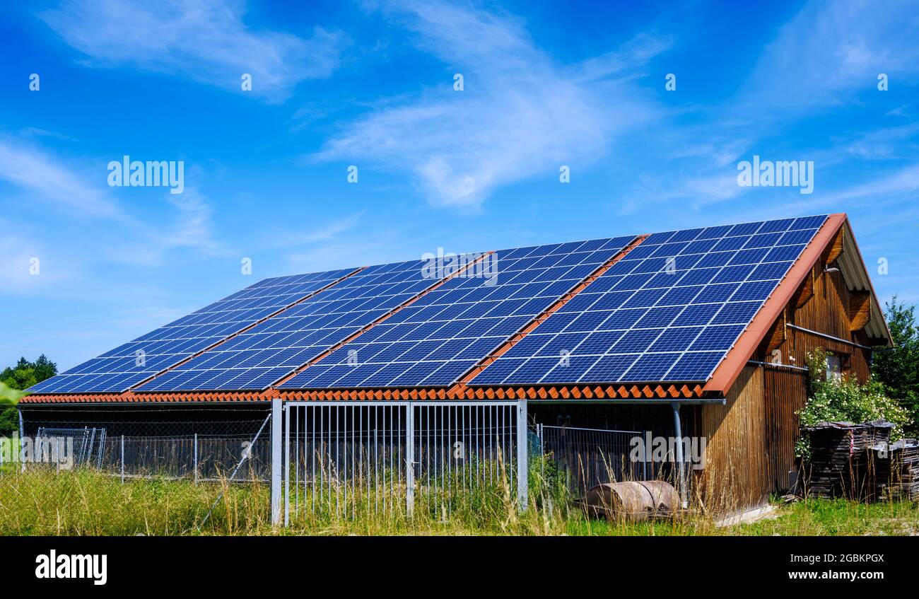 Energia Verde con collettori solari sul tetto di un edificio agricolo Foto Stock