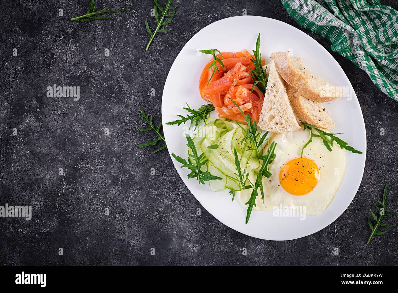 Prima colazione dietetica. Insalata di salmoni con verdure, cetrioli, uova fritte e pane. Vista dall'alto, dall'alto Foto Stock