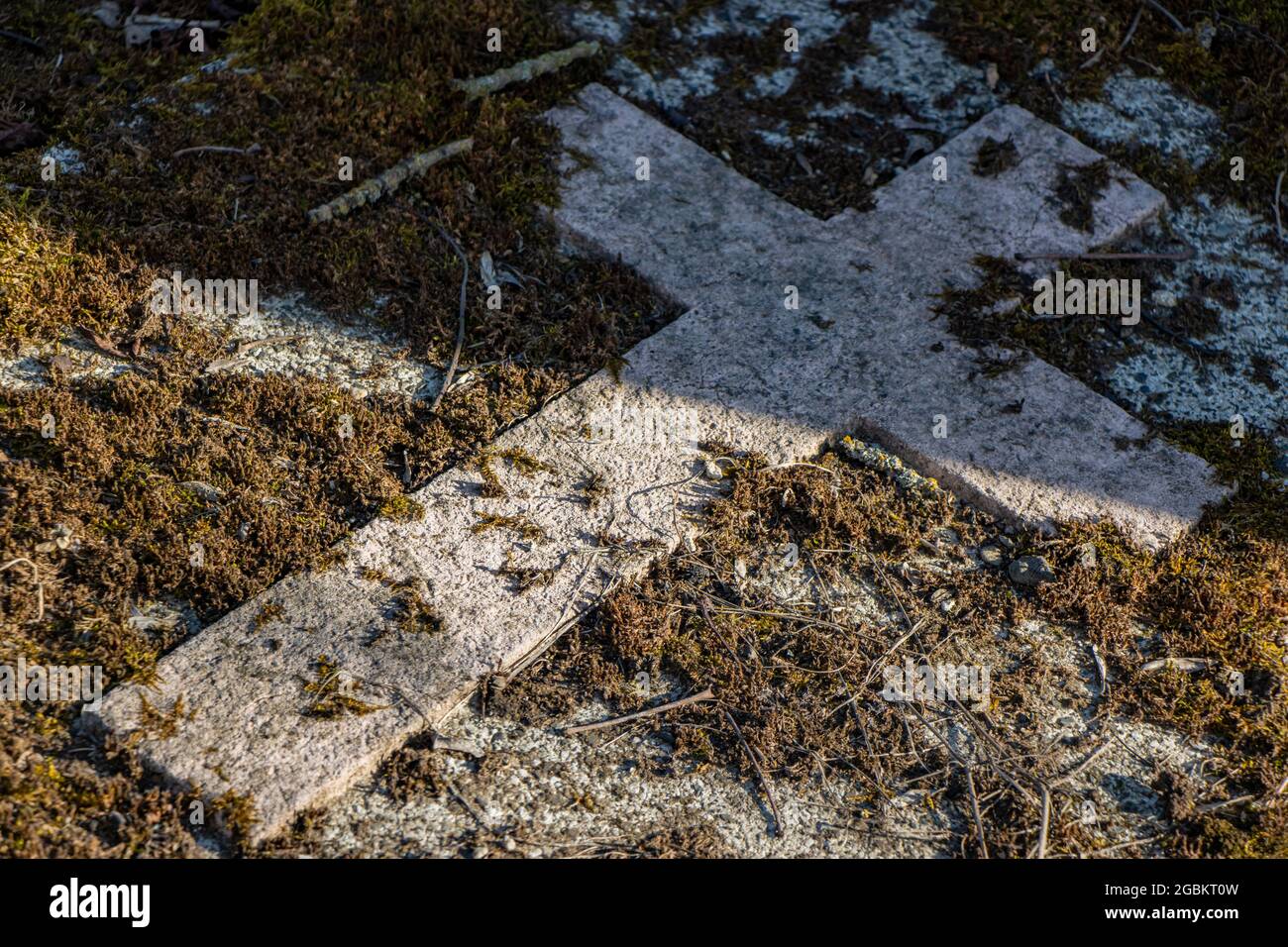 Una croce di pietra su una lapide in un cimitero. Foto Stock