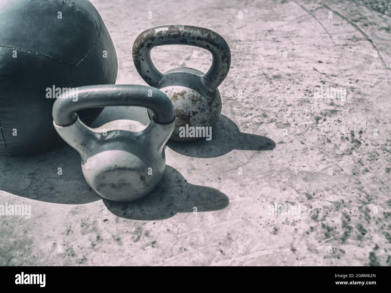 Fitness kettlebells pesi palestra sfondo. Pesi kettlebell e palestra palla allenamento all'aperto. Kettlebells peso pesante per Foto Stock