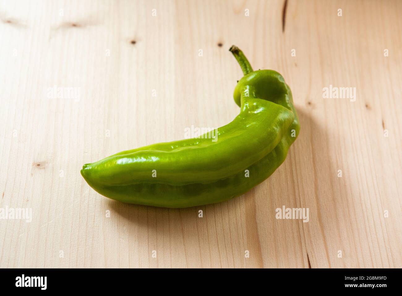 Pepe verde su tavola di legno in cucina, primo piano. Pepe verde dolce fresco su sfondo di legno, vista dall'alto Foto Stock