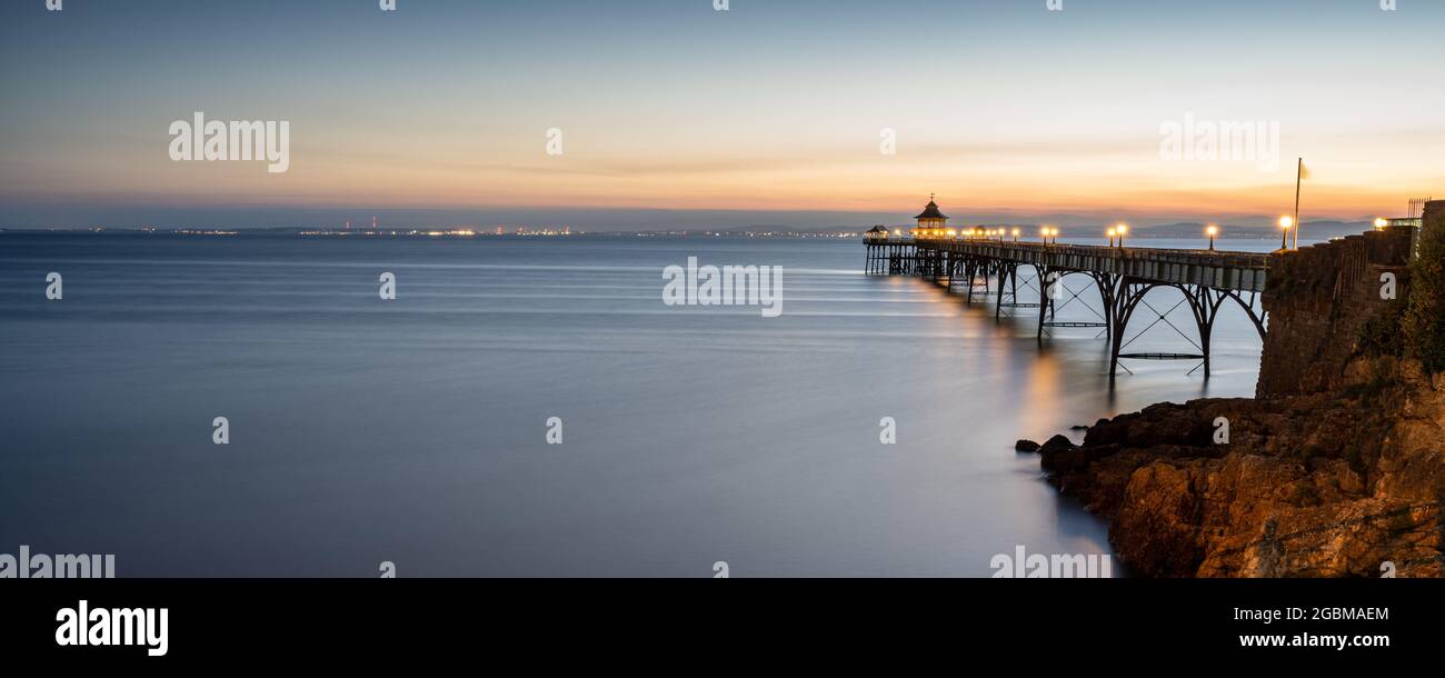 Il sole tramonta sul canale di Bristol e sul Galles del Sud al molo di Clevedon a Somerset, Inghilterra. Foto Stock