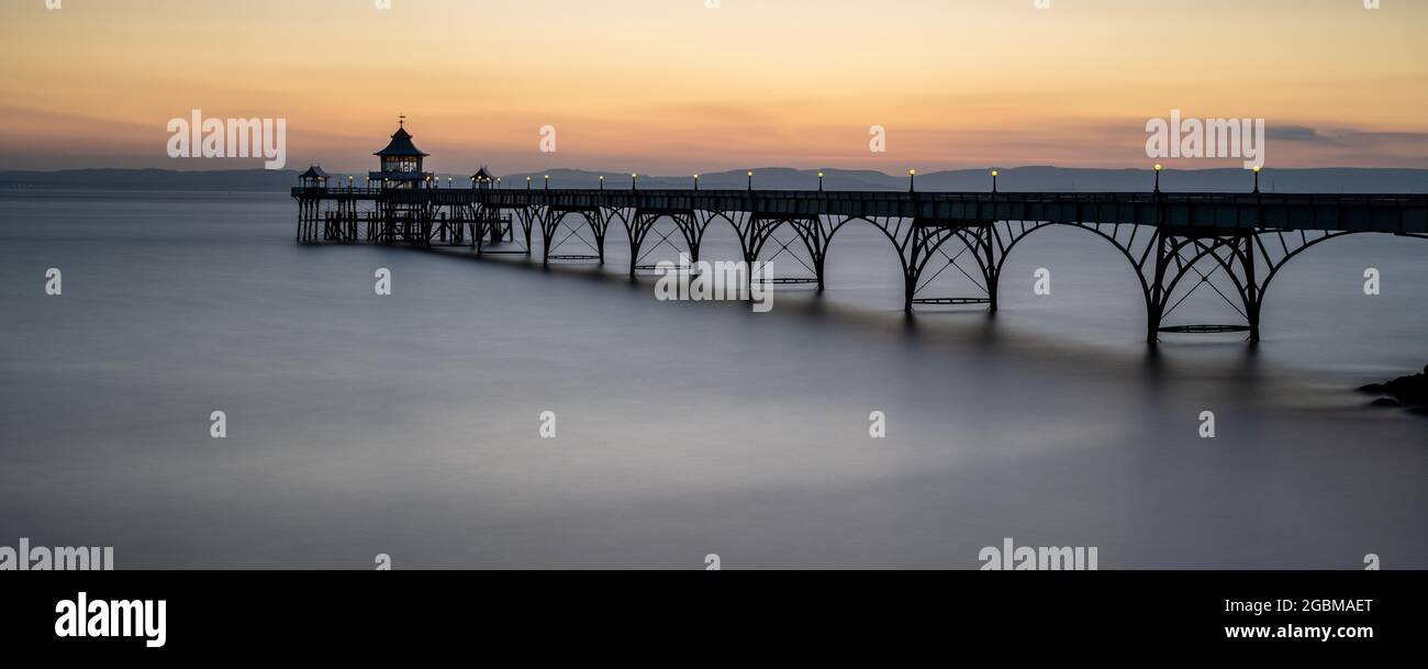 Il sole tramonta sul canale di Bristol e sul Galles del Sud al molo di Clevedon a Somerset, Inghilterra. Foto Stock