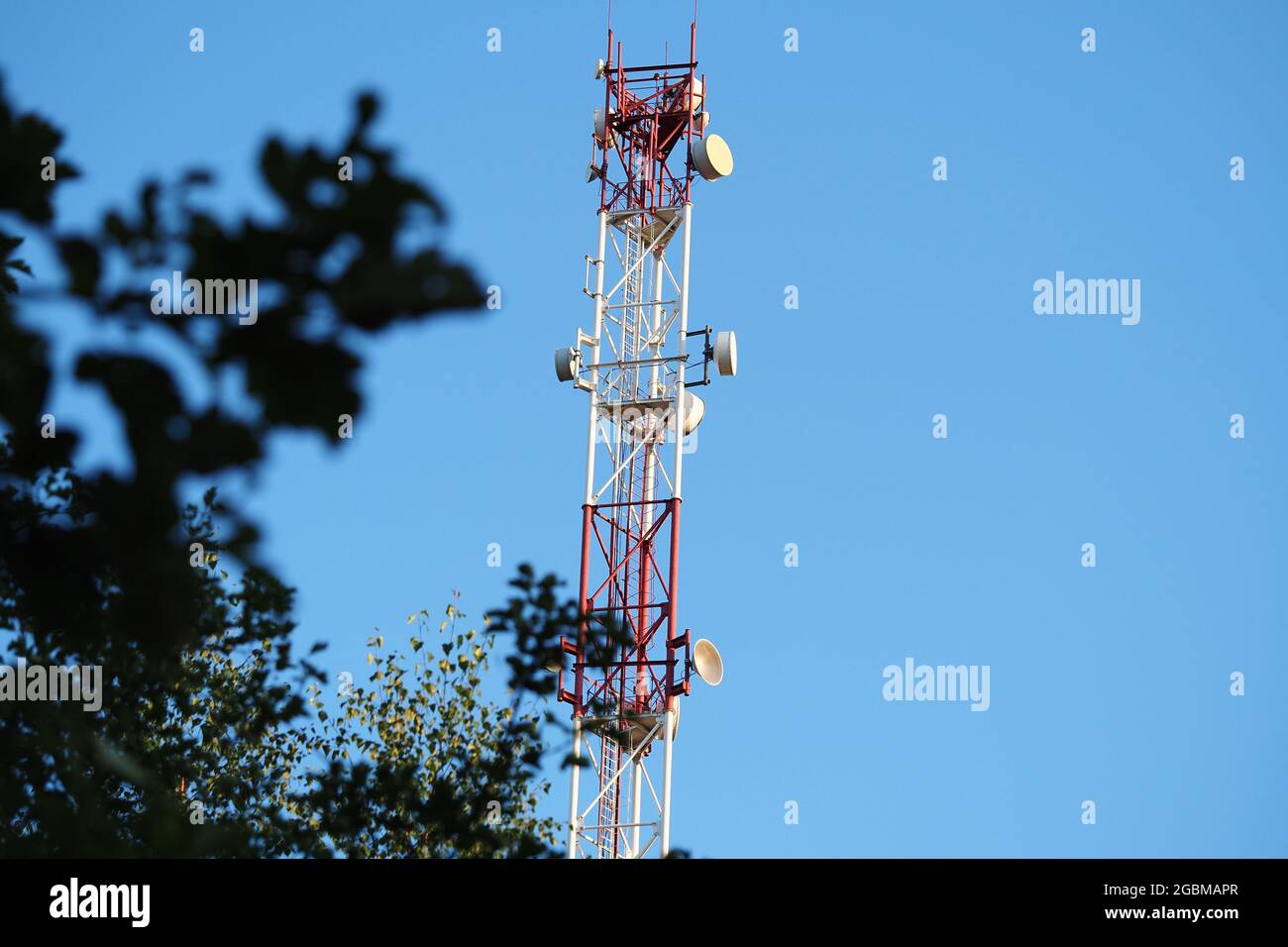 Torre per telecomunicazioni con antenna di rete cellulare 5G su sfondo blu. Foto di alta qualità Foto Stock