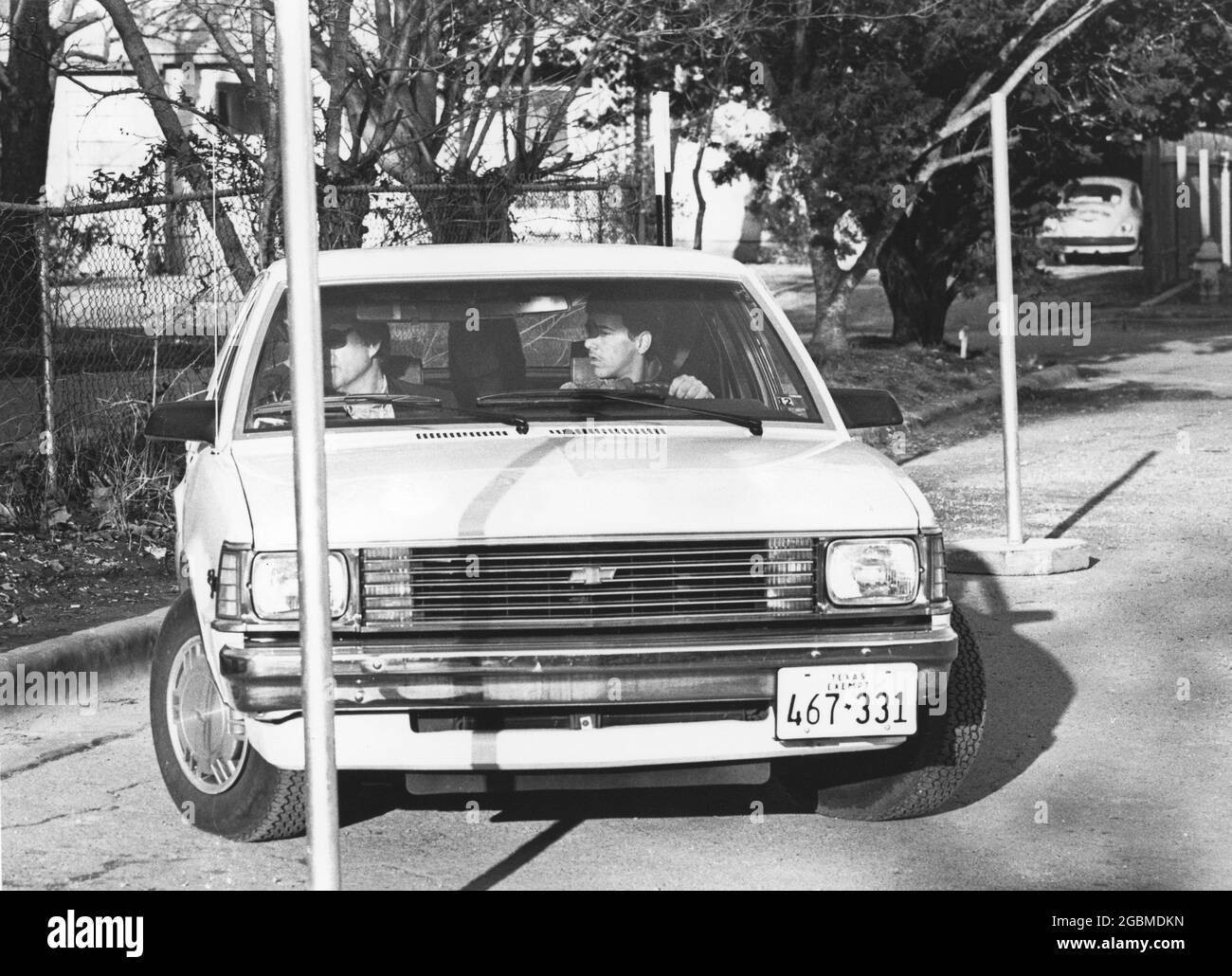 Austin Texas USA, circa 1990: Studente maschile pratica le sue abilità di parcheggio parallelo durante la classe di istruzione del conducente della scuola superiore, con istruttore seduto accanto a lui in sedile passeggero e compagno di classe seduto sul sedile posteriore. ©Bob Daemmrich Foto Stock