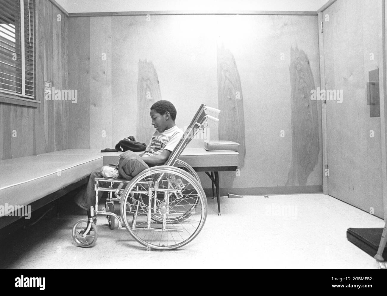 Austin, Texas USA, circa 1984: 4° grado Patrick Skeaton, che ha spina bifida e ha dovuto avere una gamba amputata mentre in 3° grado. La storia fotografica lo mostra durante un giorno tipico a scuola; qui sta facendo una pausa nell'ufficio dell'infermiera della scuola. ©Bob Daemmrich Foto Stock