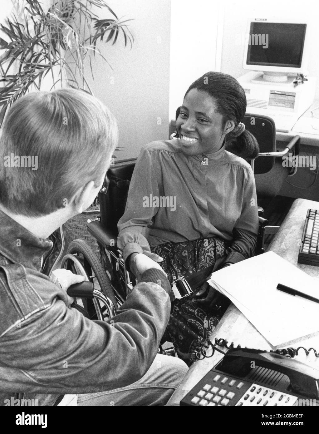 Austin Texas USA, circa 1994: Donna nera handicappata, fine anni '20, incontra il cliente nel suo ufficio. ©Bob Daemmrich Foto Stock