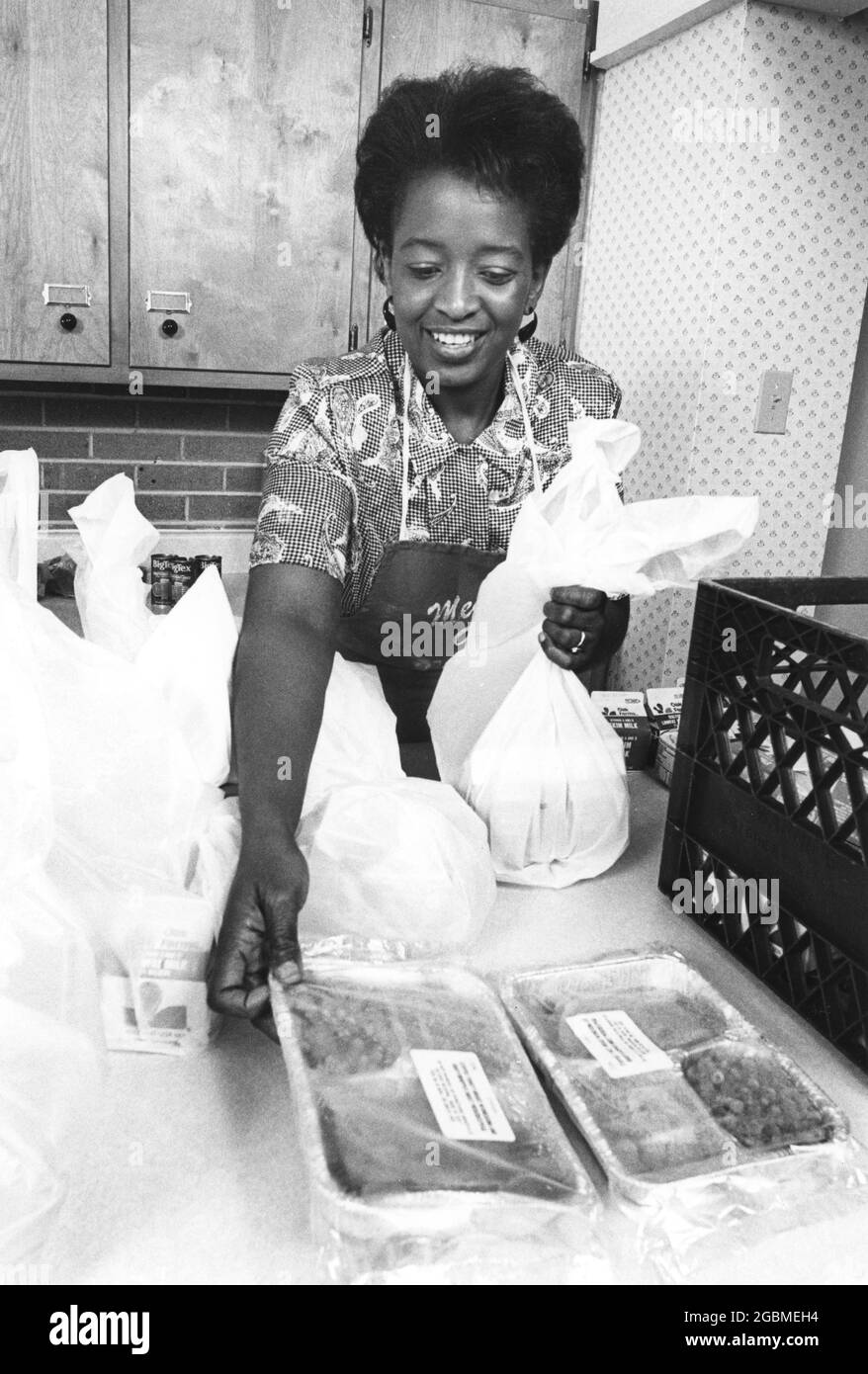 Austin, Texas USA, circa 1989: Pasti su ruote volontario Jessica Fowler impacchi su alimenti preparati per la sua corsa di consegna ai residenti a basso reddito di Austin homebound. ©Bob Daemmrich Foto Stock