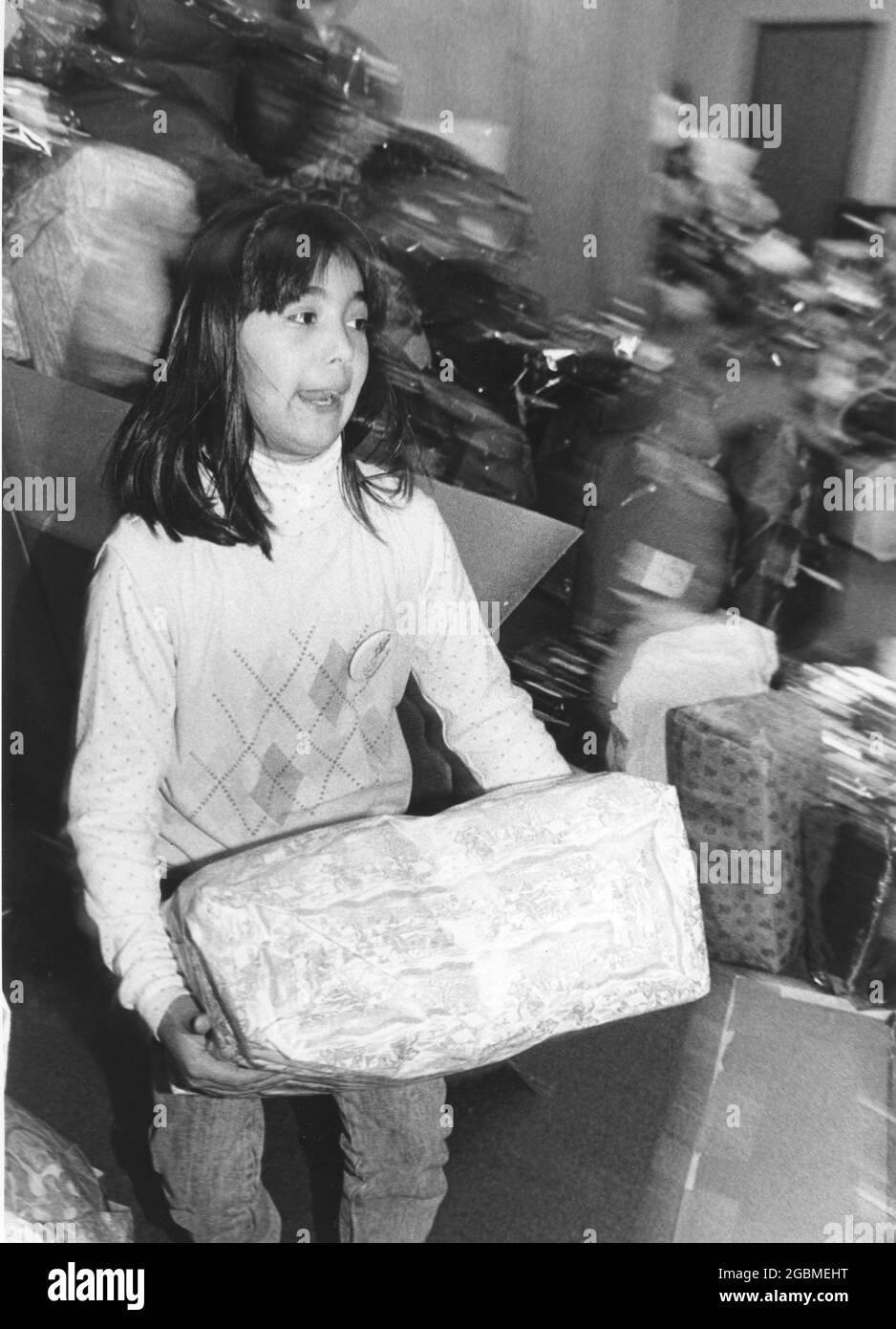 Austin Texas USA, circa 1990: Il volontario aiuta il wrap donato regalo di Natale che sarà dato alle famiglie a basso reddito attraverso il programma di festa Blue Santa del Dipartimento di polizia di Austin. ©Bob Daemmrich Foto Stock