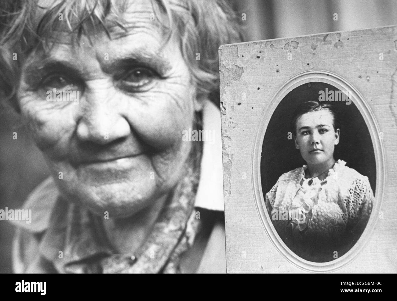 Hearne, Texas USA, circa 1978: La donna anziana tiene l'immagine del suo sé più giovane. ©Bob Daemmrich Foto Stock