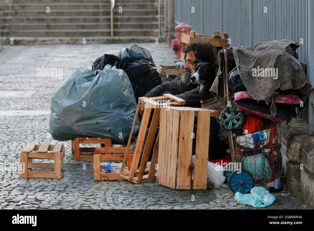 Uomo senza casa, mendicante vivere su un marciapiede durante la crisi economica in centro, in cerca di aiuto, affamato. Povertà situazione vulnerabile, problemi sociali in lat Foto Stock