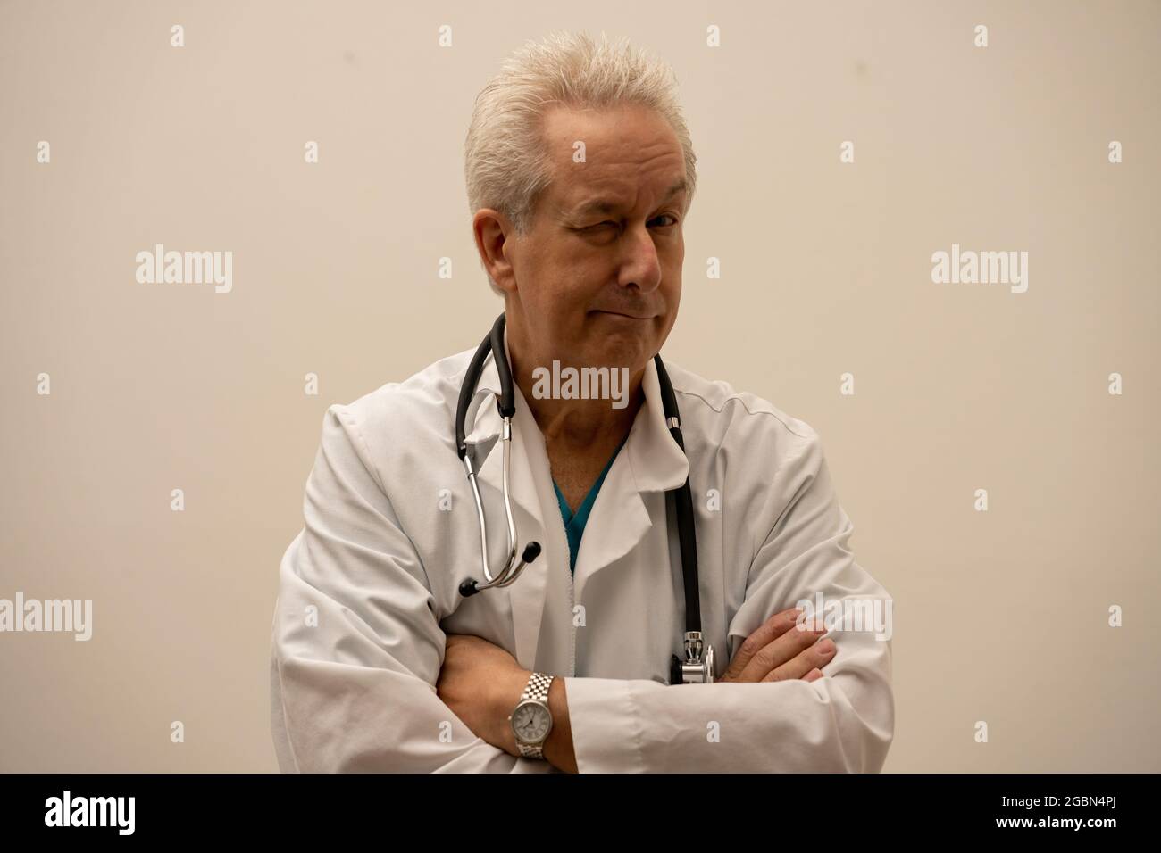 Medico che guarda la macchina fotografica con un occhio chiuso Foto Stock