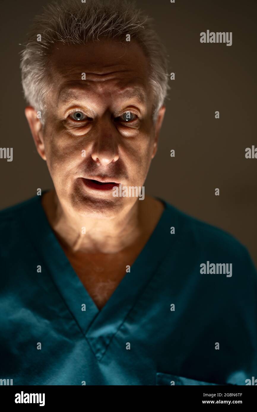 Foto di un vecchio infermiere con espressione vuota Foto Stock