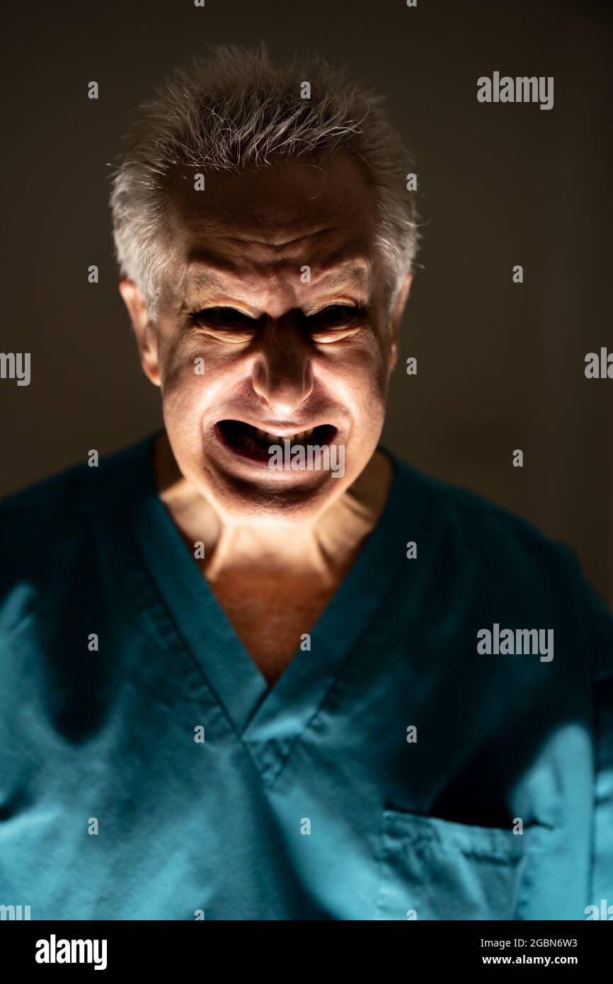 Foto di un vecchio medico malvagio infestato con una spaventosa espressione facciale Foto Stock