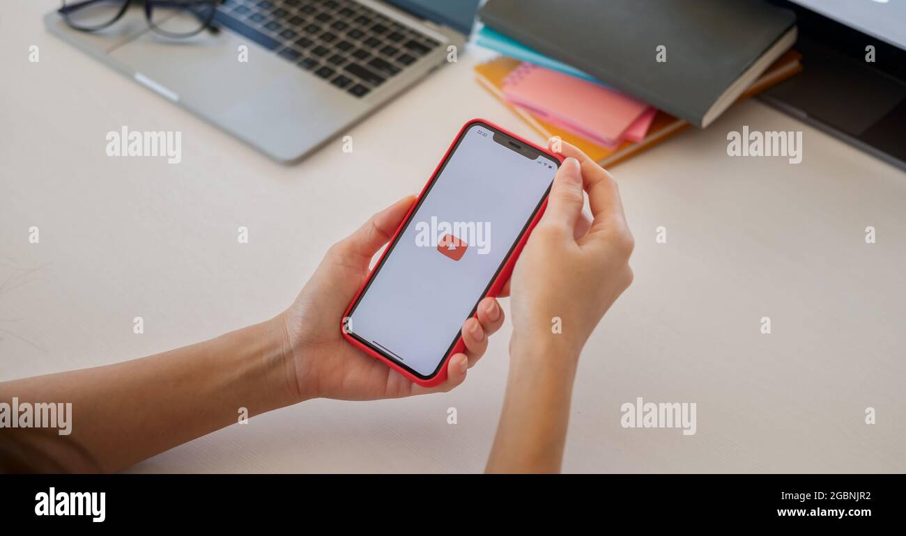 CHIANG mai, THAILANDIA - 23 MAGGIO 2021 : la mano preme sullo schermo vengono visualizzate le icone dell'app YouTube su Apple iPhone. YouTube è il popolare video online Foto Stock