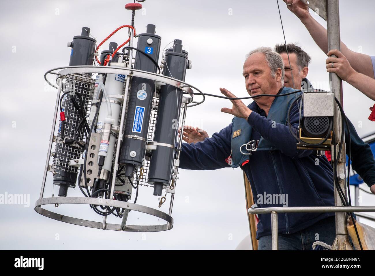 Nordsee, Germania. 22 luglio 2021. Helmo Nicolai, responsabile dell'officina dell'Università di Oldenburg, rilascia un dispositivo di misurazione CTD dal vaso di ricerca 'Otzum' nell'acqua. Il progetto "Good Coast" delle università di Hannover, Oldenburg e Braunschweig mira a indagare su come la protezione costiera e la protezione degli ecosistemi possano essere riconciliate e funzionare anche a lungo termine. A tal fine, i ricercatori utilizzano i cosiddetti laboratori reali. (A dpa 'la natura come alleato: I ricercatori testano la protezione costiera di domani') Credit: Sina Schuldt/dpa/Alamy Live News Foto Stock