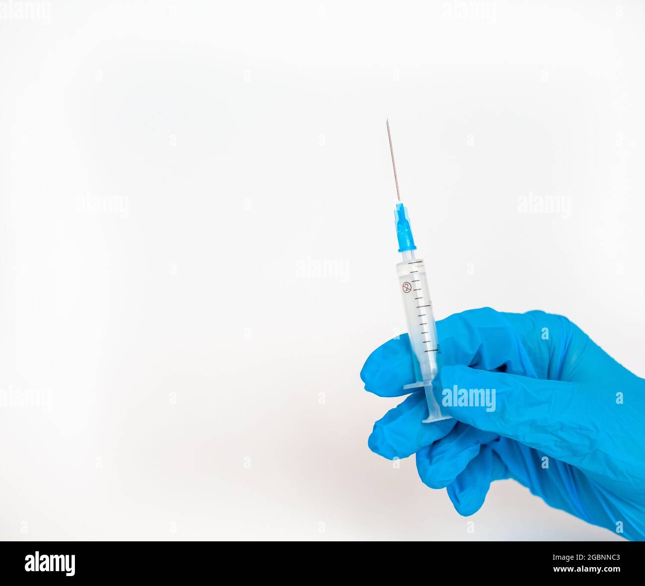 Il medico tiene una siringa di vaccinazione su sfondo bianco. Un colpo dal coronovirus. Vaccinazione contro infezioni pericolose o trattamento di di Foto Stock