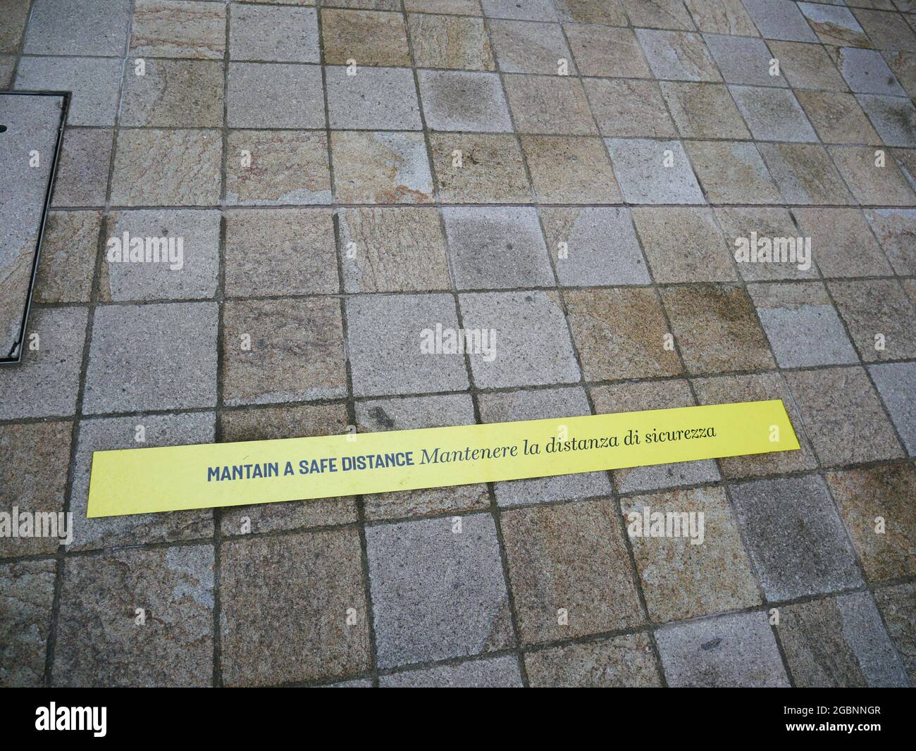 Traduzione italiana e inglese di mantenere un segnale di distanza di  sicurezza sul pavimento Foto stock - Alamy