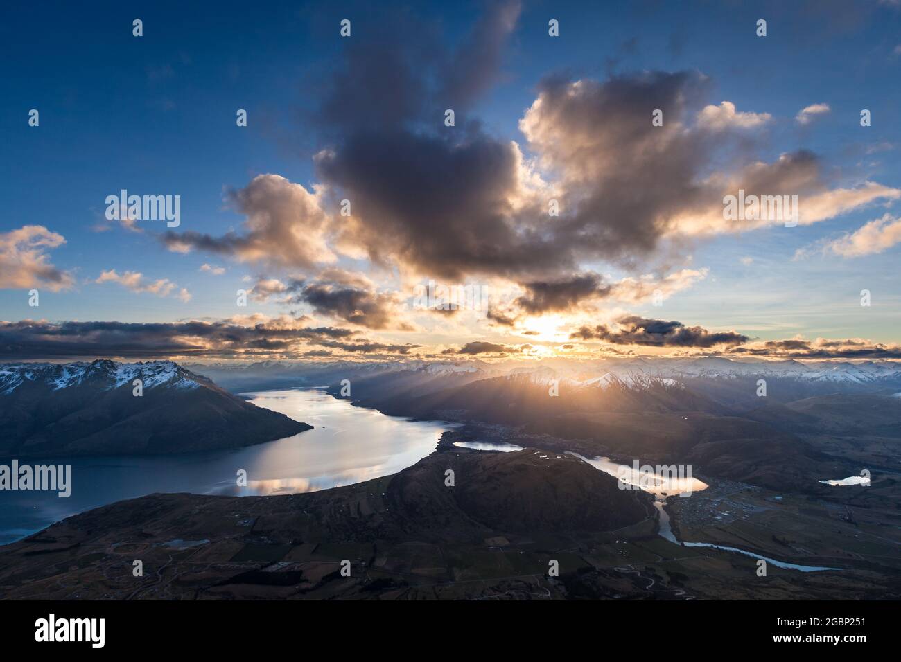 Il sole tramonta sulle Alpi meridionali, sul lago Wakatipu e Frankton Arm, Queenstown, Nuova Zelanda Foto Stock