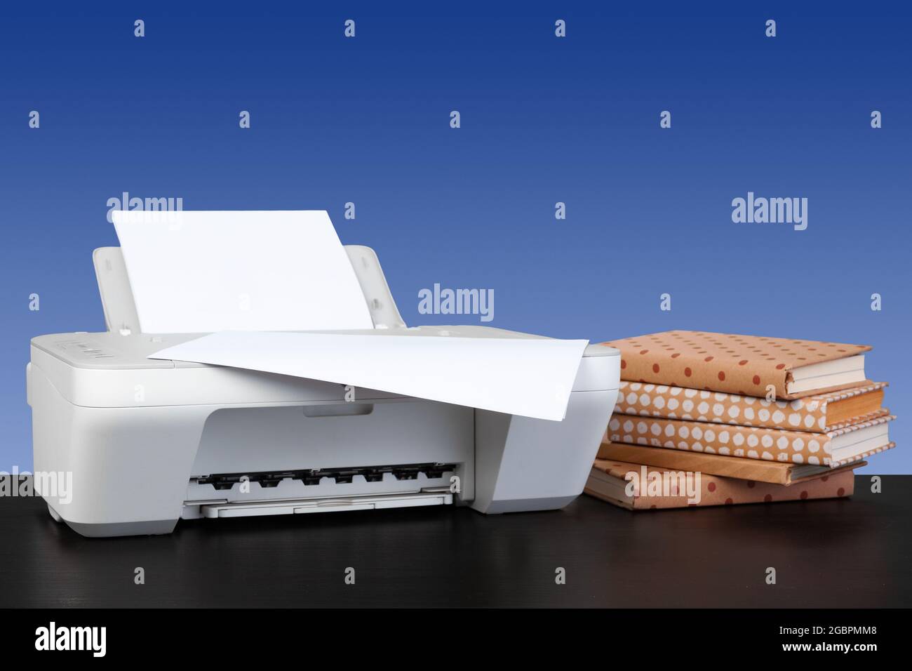 Stampante laser compatta su una scrivania nera con sfondo sfocato Foto stock  - Alamy