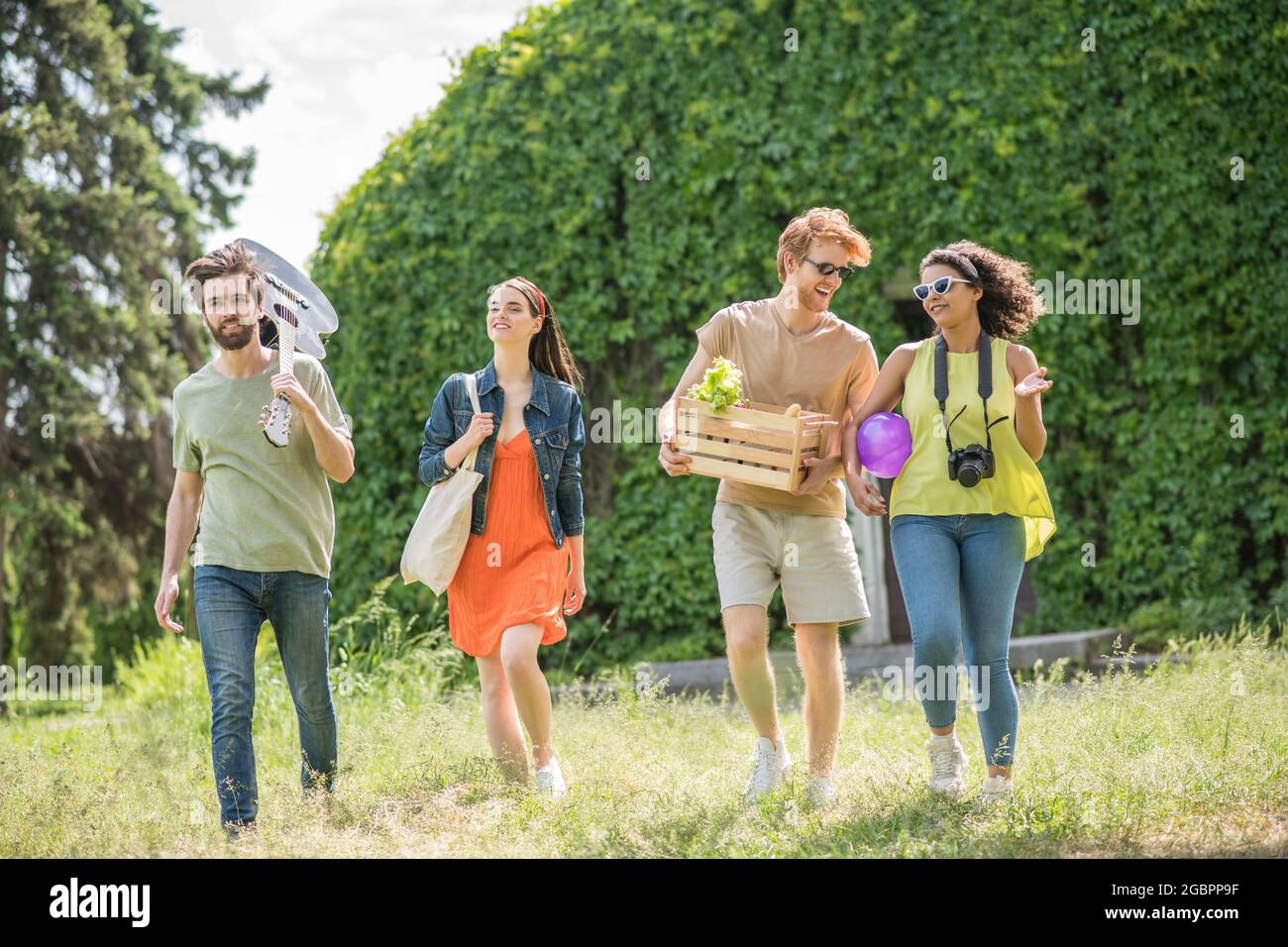 Due ragazzi e fidanzate che vanno al picnic Foto Stock