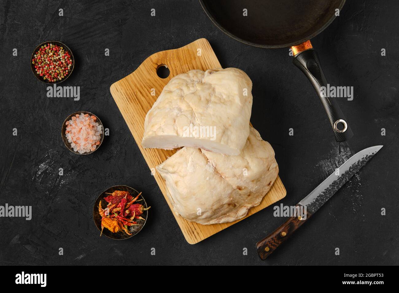 Vista dall'alto della coda di grasso di agnello sul tavolo da cucina con sale e pepe Foto Stock