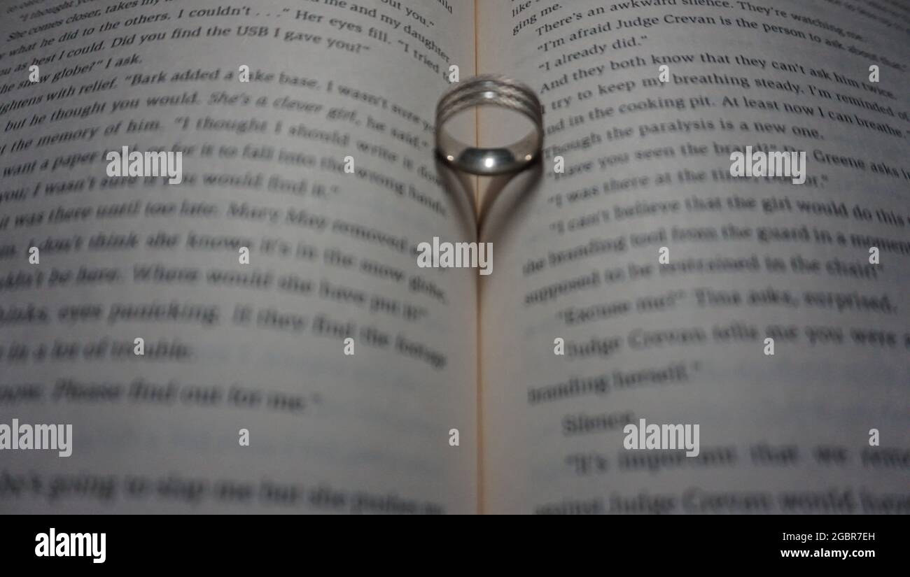 anello che riflette un cuore sul libro. Foto Stock
