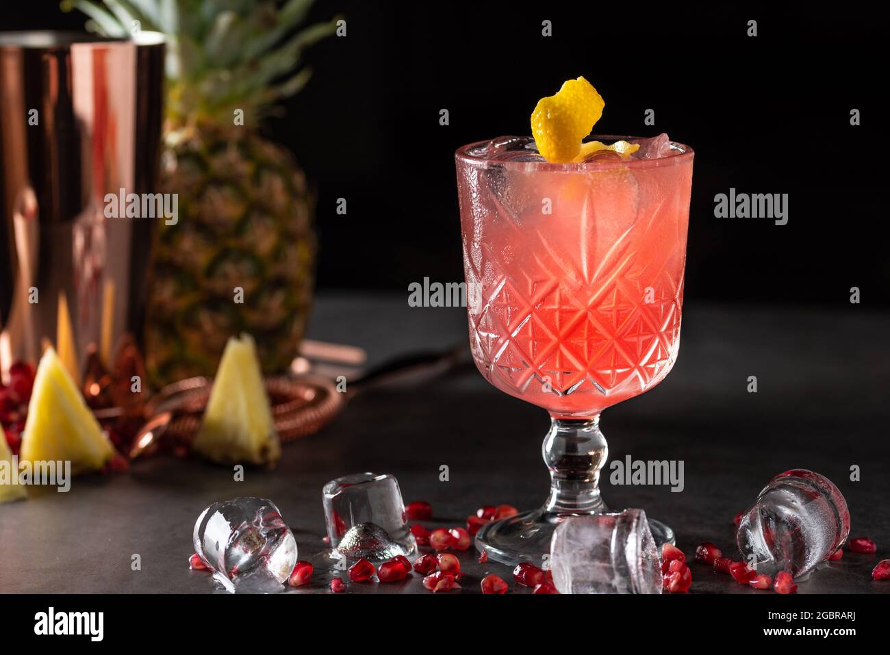 cocktail estivo di melograno e ananas fresco e leggero con cubetti di ghiaccio Foto Stock