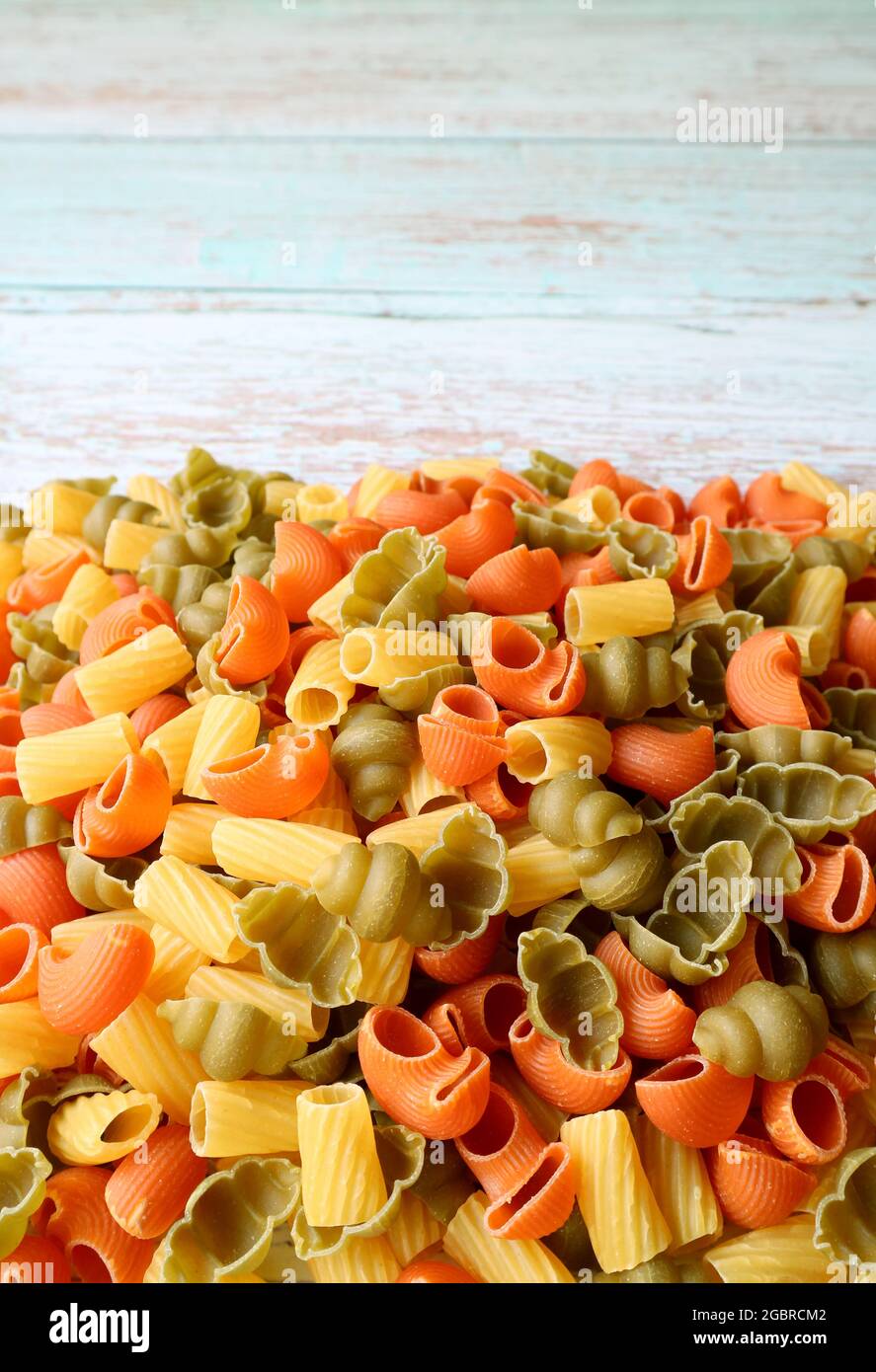 Pila di Pasta di Vegeroni essiccata su tavola di legno con Copy Space Foto Stock