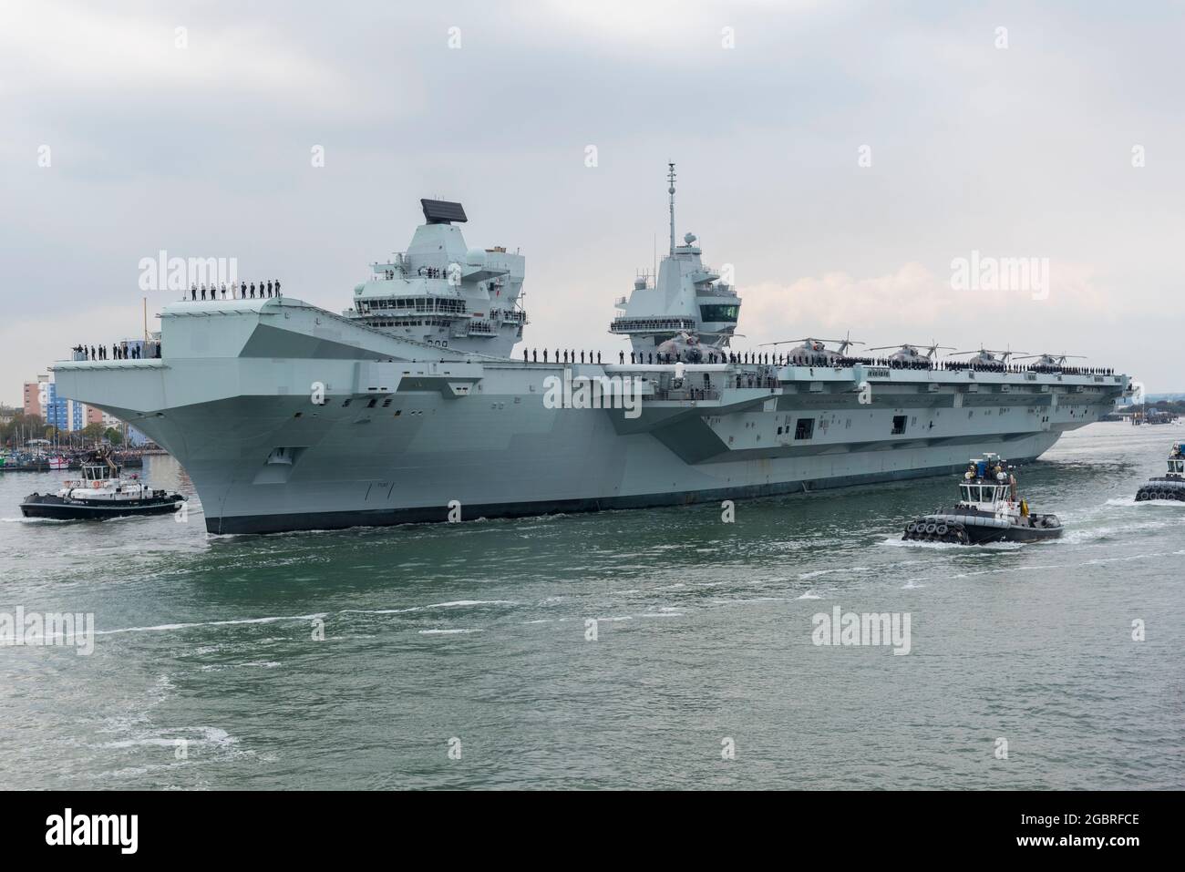 HMS Queen Elizabeth parte da Portsmouth trasportando elicotteri Merlin sul ponte Foto Stock