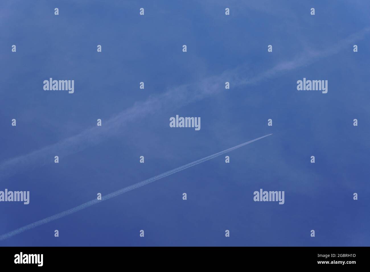 Foto del getto di vapore e impronta di carbonio realizzata da aerei commerciali. Cielo blu beatiful in una giornata di sole chiaro. Sfondo. Foto Stock