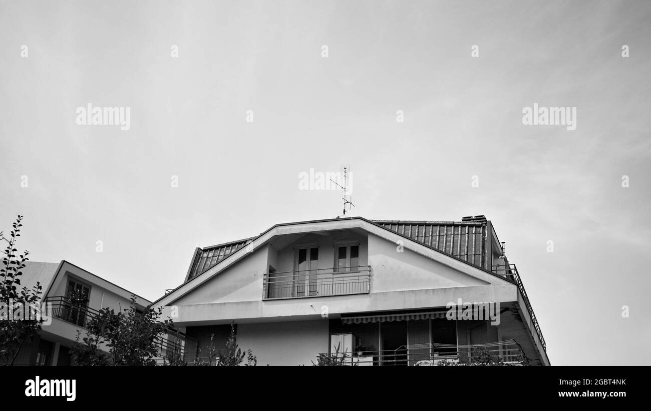 Edificio residenziale italiano con tetto prismatico rifinito con piastrelle e balconi (Marche, Italia, Europa) Foto Stock