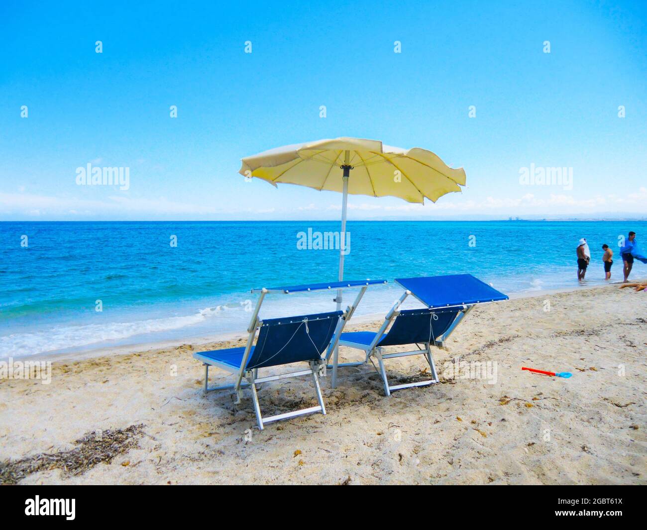 Ombrellone giallo e due lettini blu di fronte al mare smeraldo e spiaggia  di sabbia bianca a Ezzi Mannu nel mese di agosto 2021, spiaggia di Pazzona,  Sardegna, i Foto stock - Alamy