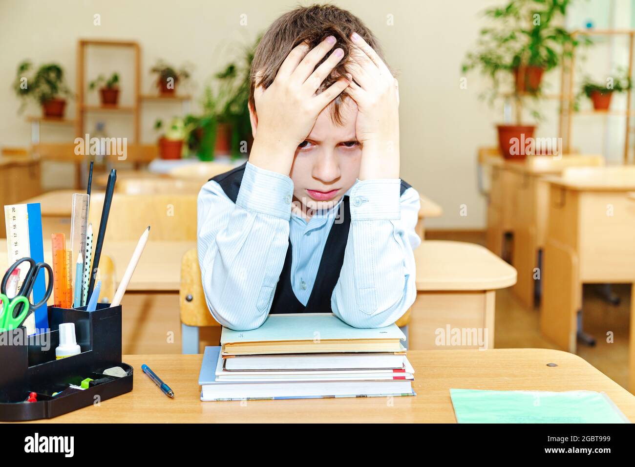 Scolaro serio in classe. Studente della scuola elementare. Ritorno a scuola. Foto Stock