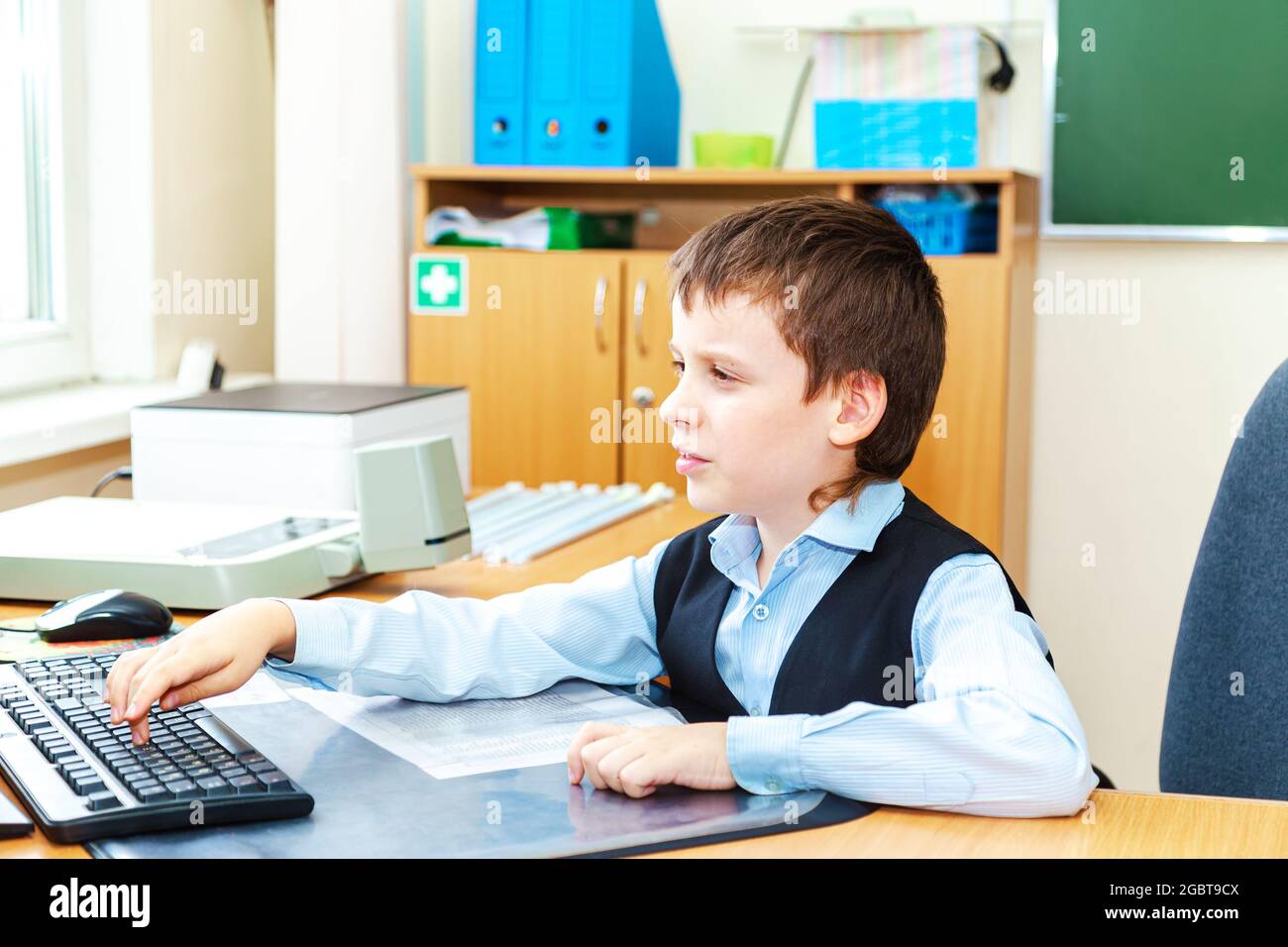 Scolaro serio in classe. Studente della scuola elementare. Ritorno a scuola. Foto Stock