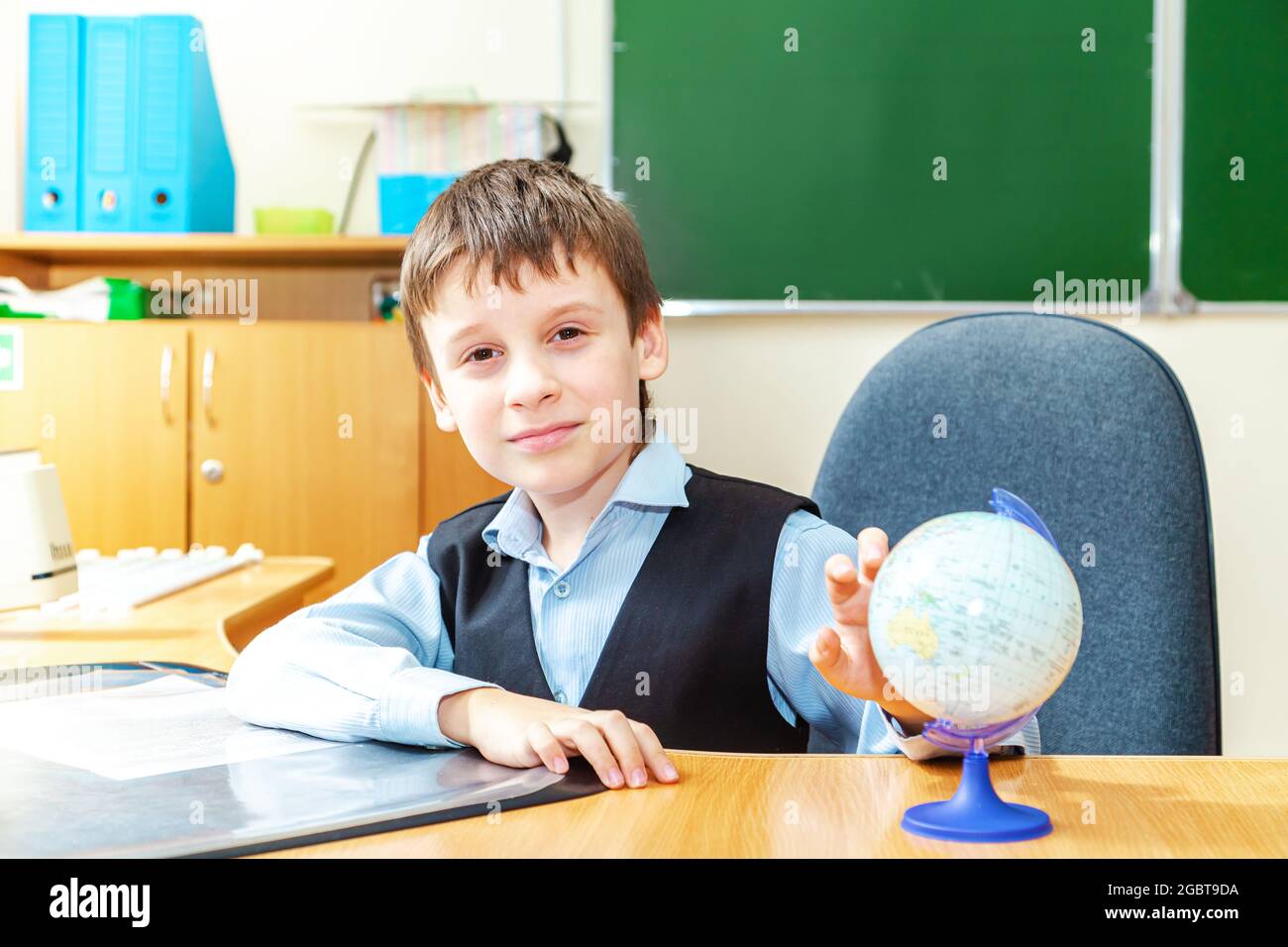 Scolaro serio in classe. Studente della scuola elementare. Ritorno a scuola. Foto Stock