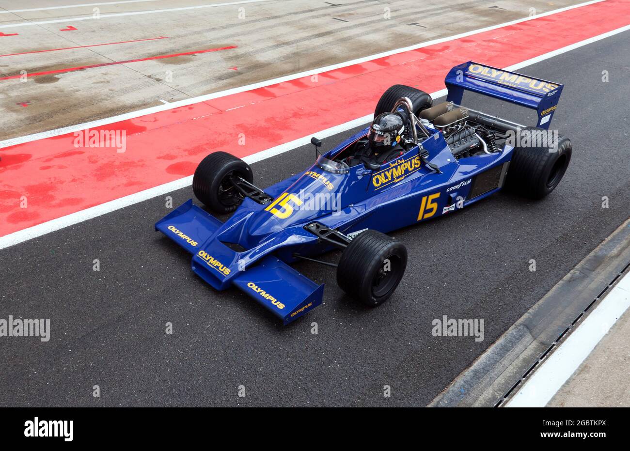 Michel Baudoin guida il suo Hesketh 308E, lungo l'International Pit Lane alla fine del Murray Walker Memorial Trophy per la corsa storica di F1 Masters Foto Stock