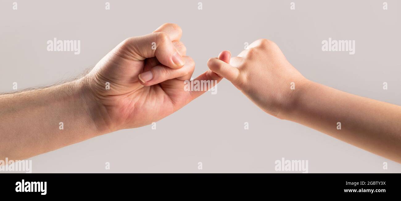 Mostra amicizia e perdono. Amicizia di generazioni. Padre, la mano di figlia che fa concetto di amicizia di promessa. I bambini agganciano un dito piccolo insieme Foto Stock