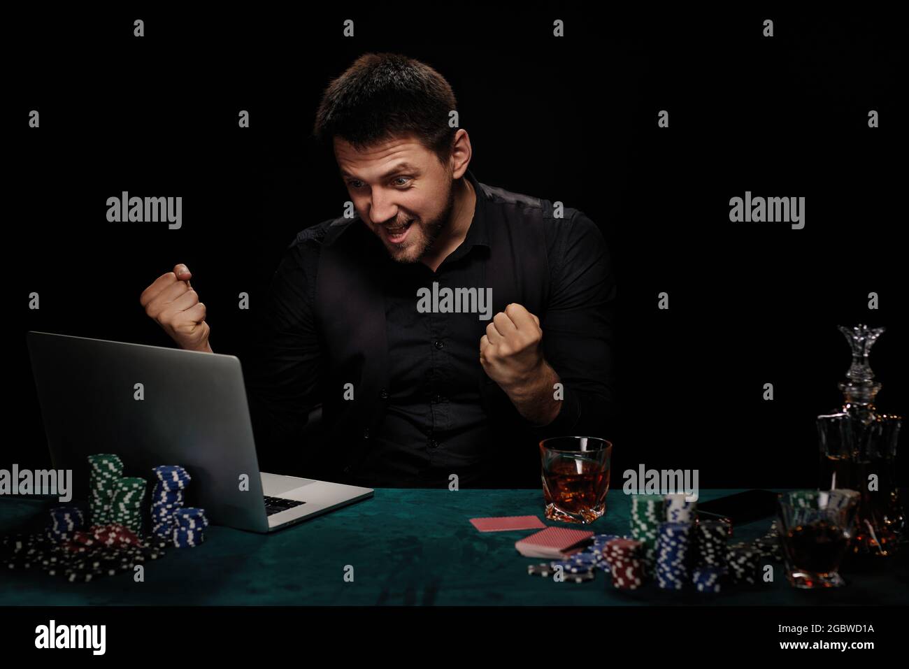 Uomo bearded del giocatore in linea del casino che celebra la vittoria Foto Stock