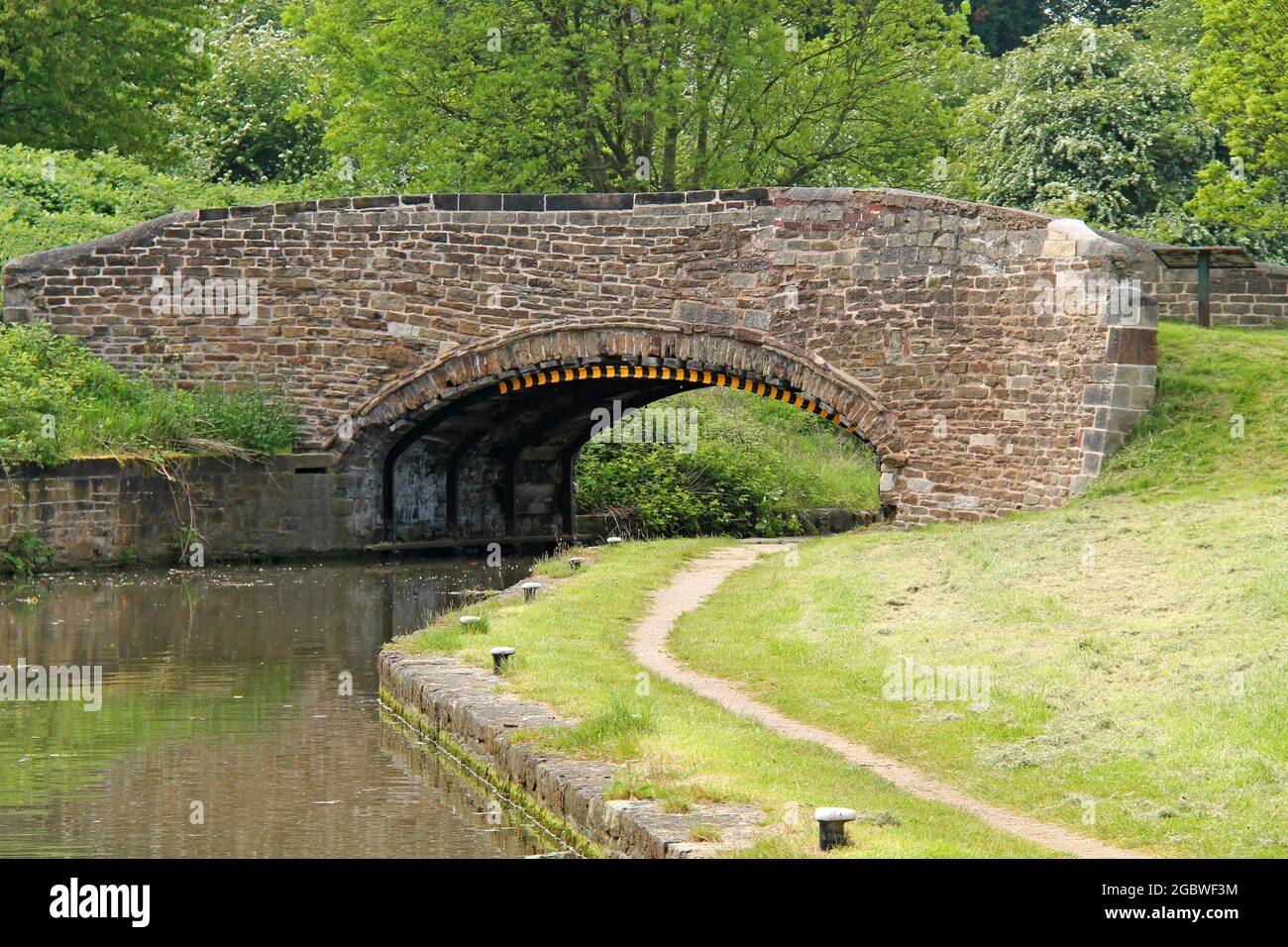 Un classico ponte in pietra costruito su un canale e alzaia. Foto Stock