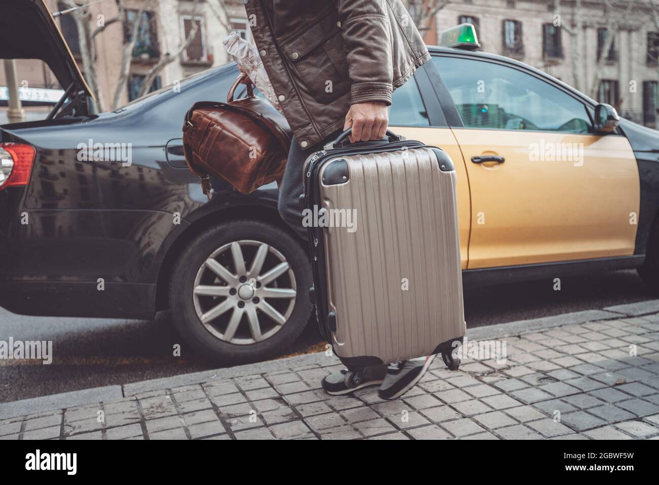 Uomo d'affari in partenza per aereo imbarco taxi con bagagli a mano che imballano camion di auto per vacanze di viaggio Foto Stock