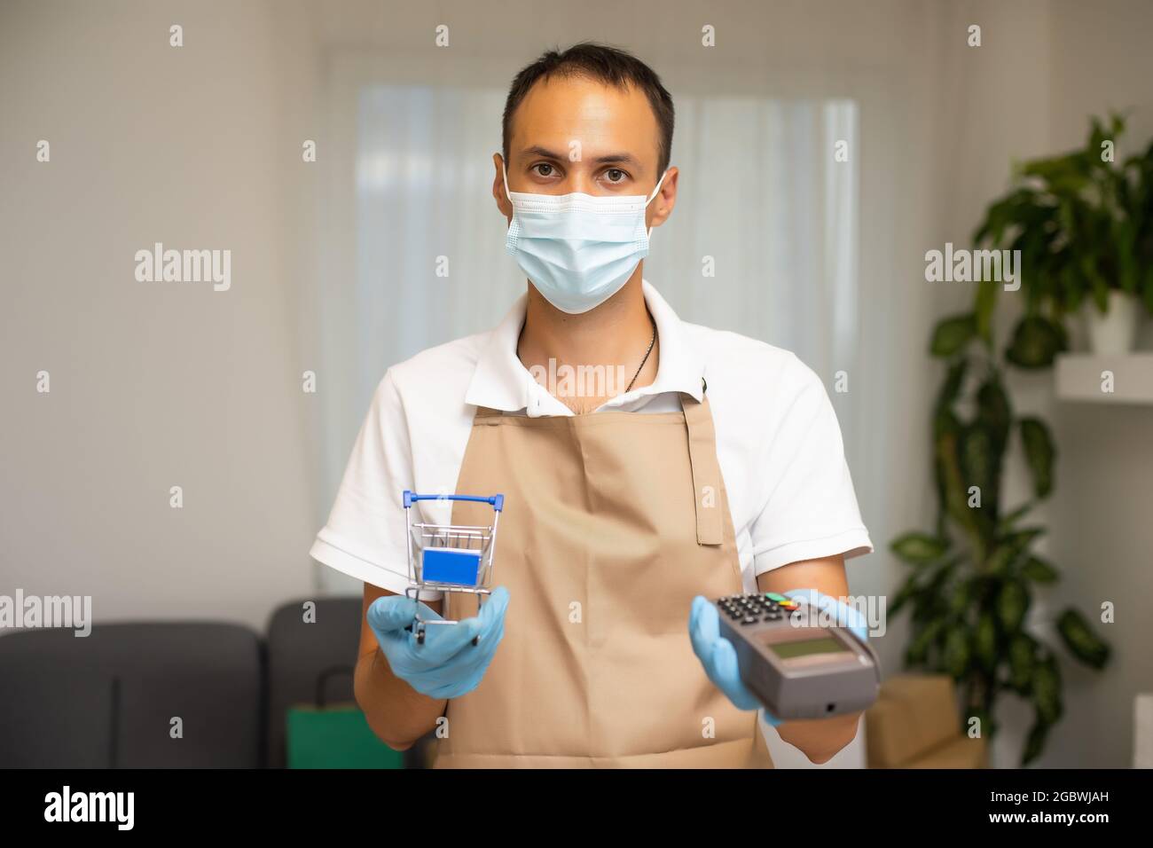 Ultimo passo dello shopping è il pagamento. Un uomo che detiene una carta di cassa registro. Lettore di carta di credito Foto Stock