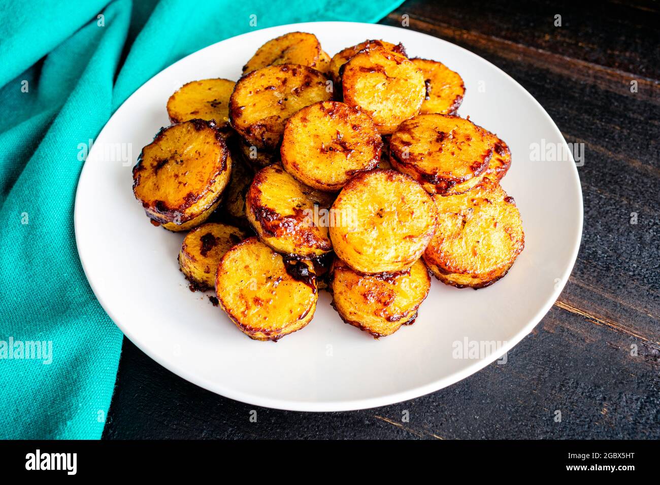 Piantane dolci cotte alla cannella al caramello: Un piatto di piantine cotte al forno ricoperte di cannella e zucchero caramellato Foto Stock