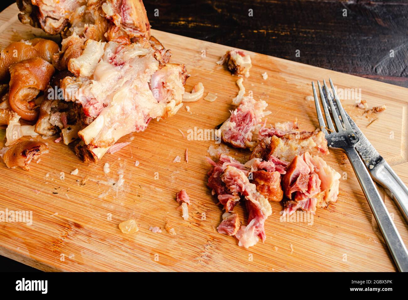 Rimozione della carne dai prosciutto cotto affumicato: Taglio della carne di maiale affumicato Foto Stock