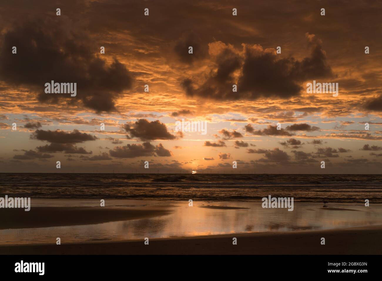 Un favoloso caldo tramonto arancione, con vista dalla spiaggia di Egmond aan Zee, Olanda del Nord, Paesi Bassi. Foto Stock