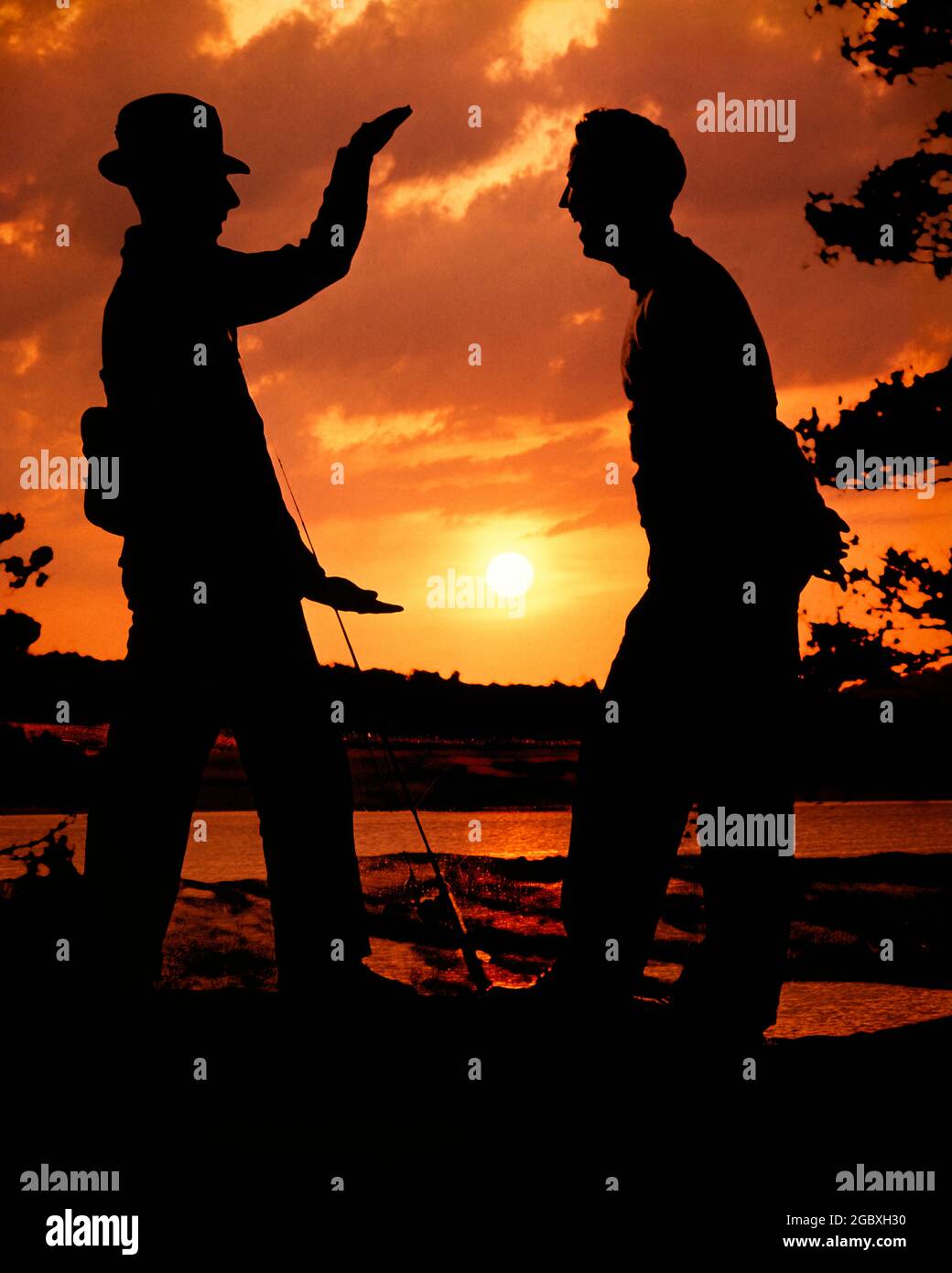 1950 SILHOUETTE ANONIMA DI DUE UOMINI UNO CHE INDOSSA CAPPELLO CHE TIENE CANNA DA PESCA CHE RACCONTA LA STORIA DEL GRANDE CHE SI È ALLONTANATO - KA1570 HAR001 HARROD SILHOUETTE DI DIMENSIONI UMOROSE AVVENTURA TEMPO LIBERO SILHOUETTE RICREAZIONE COMICO RACCONTARE CONNESSIONE CONCETTUALE COMMEDIA RACCONTO ANGLING ANONIMO ESAGERAZIONE OTTENUTO ALTO RACCONTO TOGETHERNESS HAR001 VECCHIO STILE Foto Stock