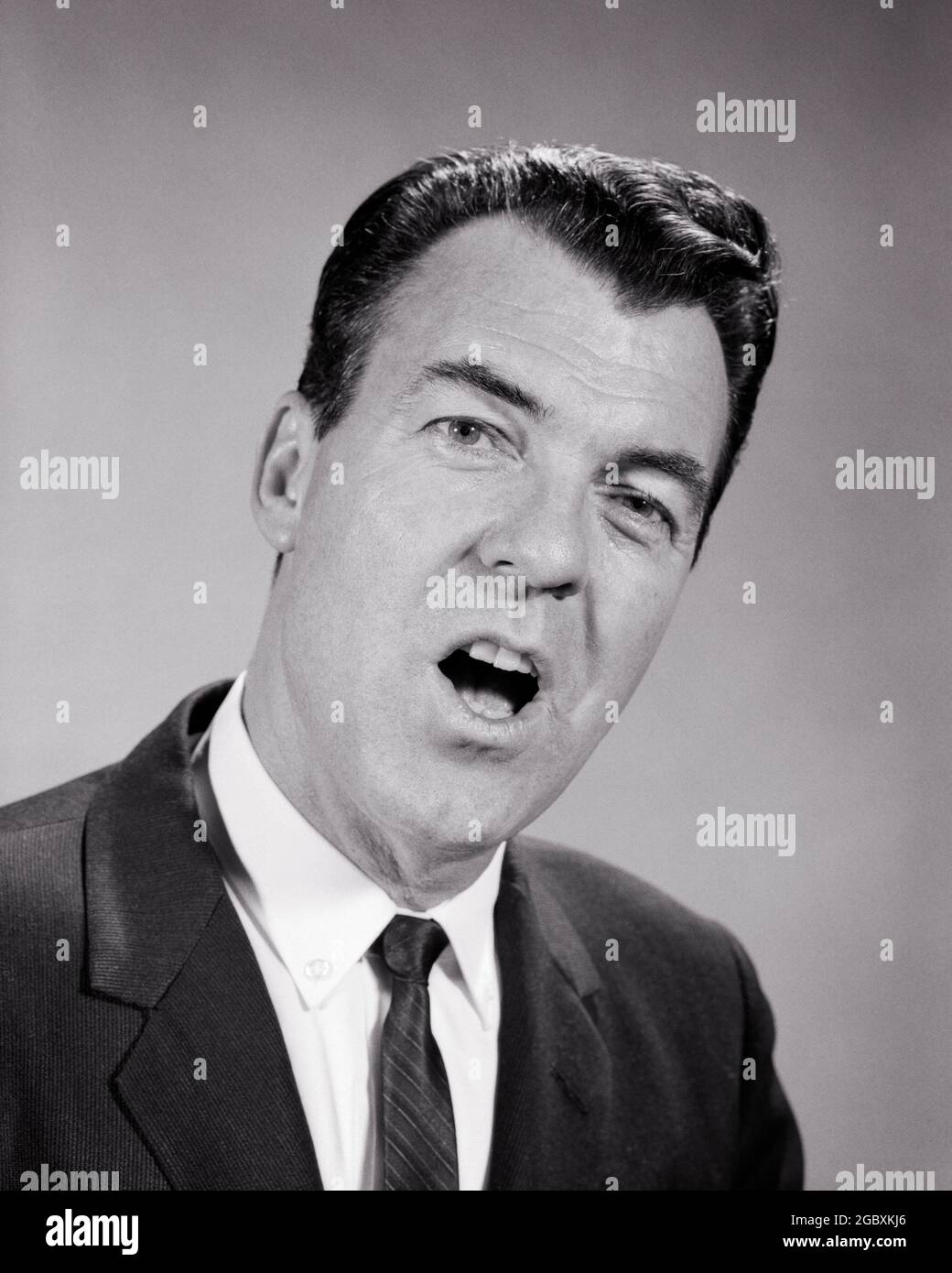 1950S 1960S ANNOIATO UOMO DI AFFARI BOCCA APERTA LAMENTANDO CANTANDO PARLARE ESPRIMENDO UN'OPINIONE URLANDO GUARDANDO LA MACCHINA FOTOGRAFICA - P7020 HAR001 HARS COMUNICAZIONE PREOCCUPAZIONE ANNOYED STUDIO SHOT MOODY COPIA SPAZIO PERSONE MASCHI TORMENTATO B&W INTERESSATO TRISTEZZA URLANDO OCCHIO CONTATTO BRUNETTE ABITO E CRAVATTA CHE LAMENTANO L'ECCITAZIONE DELLA TESTA E DELLE SPALLE OPINIONE UN GLUM DI UMORE CHE ESPRIME L'UOMO MEDIO-ADULTO MISERABILE NERO E BIANCO ETNIA CAUCASICA HAR001 BOCCA APERTA VECCHIO STILE Foto Stock