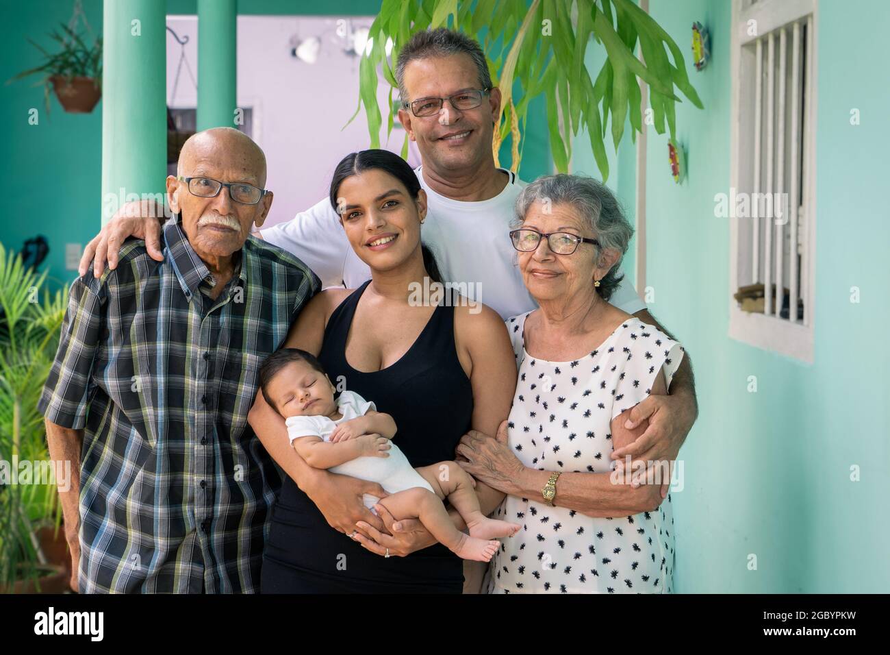 Foto di un gruppo di persone. Un bambino tra le braccia di una giovane donna, di un uomo e di una coppia anziana Foto Stock