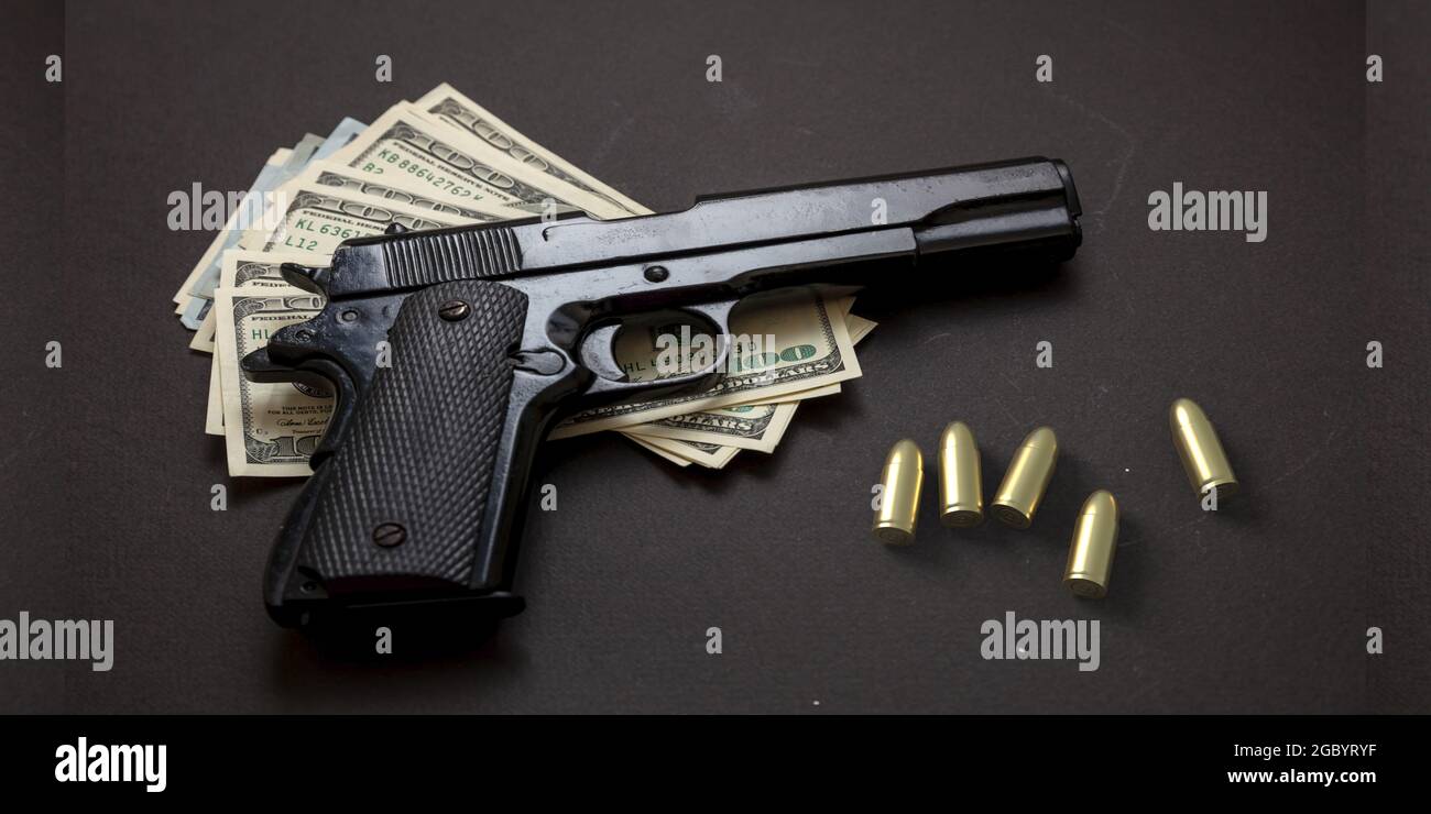 Crime Concept, pistola a pistola da 9 mm e banconote in dollari americani su sfondo nero. Concetto di denaro criminale, mafia e corruzione, Foto Stock